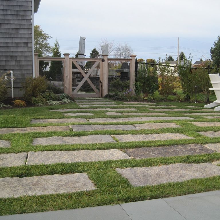 Feature image for Reclaimed Granite Rustic Plank Pavers. The image shows this material being used in a patio pavers application. The dominant color shown is gray; with beige, brown, orange/rust, purple, white, tan and cream secondaries. The color mix creates a warm feeling. Speckled and blotched color patterns.