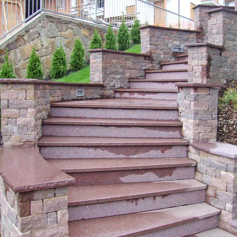 Feature image for Porphyry Worked Surface - Rosso Antico. The image shows this material being used for landings, monolithic steps and treads. Dominant colors shown are gray and purple; with brown and pink secondaries. The color mix creates a warm feeling. Speckled and fine speckled color patterns.