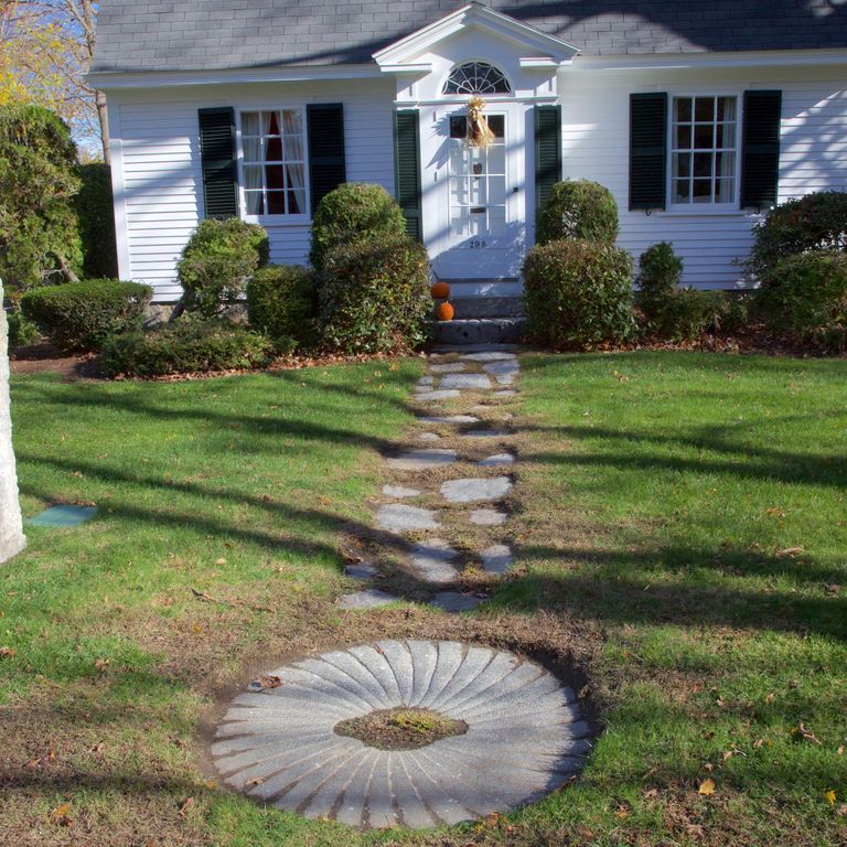 Feature image for Reclaimed Granite Millstones. The image shows this material being used in a garden accents application. The dominant color shown is gray. The color mix creates a cool feeling. Fine speckled color pattern.