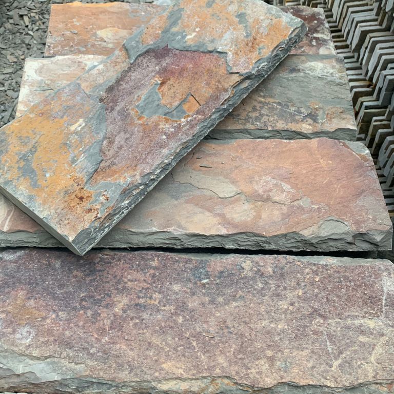 Close-up image for Mandarin Rusty Slate. The surface finish shown is natural cleft. Dominant colors shown are gray, orange/rust and purple; with beige, brown, green, white, tan and cream secondaries. Exhibits 
