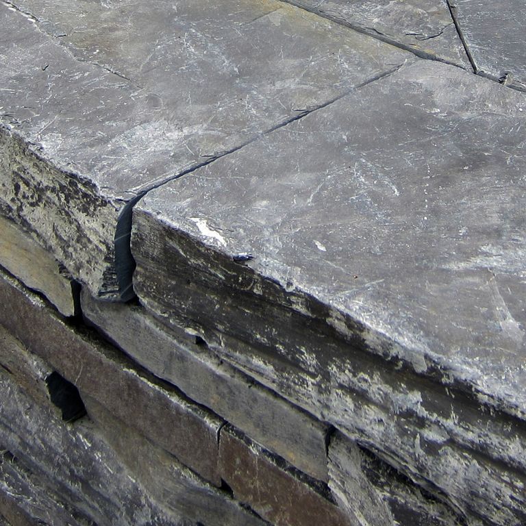 Close-up image for Monson Black Slate. The surface finishes shown are natural cleft and split-face with flat plane. The dominant color shown is gray; with brown and orange/rust secondaries. The color mix creates a cool feeling. Regular and cloudy color patterns.