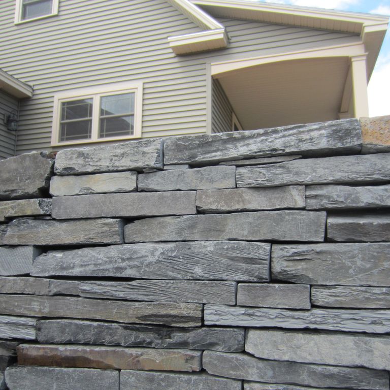 The image shows this material being used in a landscape wallstone application.