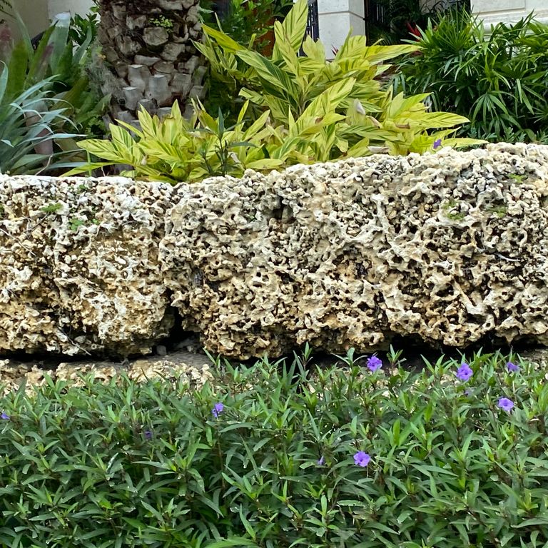 The image shows this material being used in a landscape wallstone application.