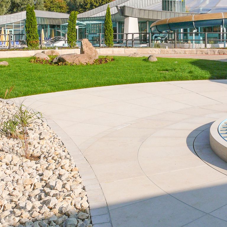 Application image for Bavarian Limestone - Beige. The image shows this material being used in a patio pavers application. The surface finish shown is sand blasted. Dominant colors shown are beige and cream. The color mix creates a warm feeling. Solid color pattern.