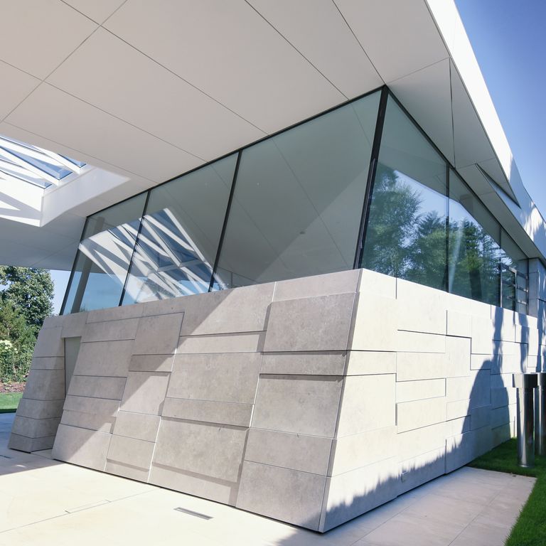 Application image for Bavarian Gray Limestone. The image shows this material being used for full bed veneer and thin veneer. Dominant colors shown are gray and white; with a beige secondary. The color mix creates a cool feeling. Regular, blotched and cloudy color patterns. Contains mineral inclusions.