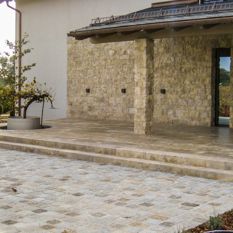 Application image for Bavarian Dolomite - Gray. The image shows this material being used for patio pavers, treads, full bed veneer and thin veneer. The surface finish shown is a combination of honed and split-face. Dominant colors shown are brown and gray. The color mix creates a warm feeling. Blotched color pattern. Contains voids.