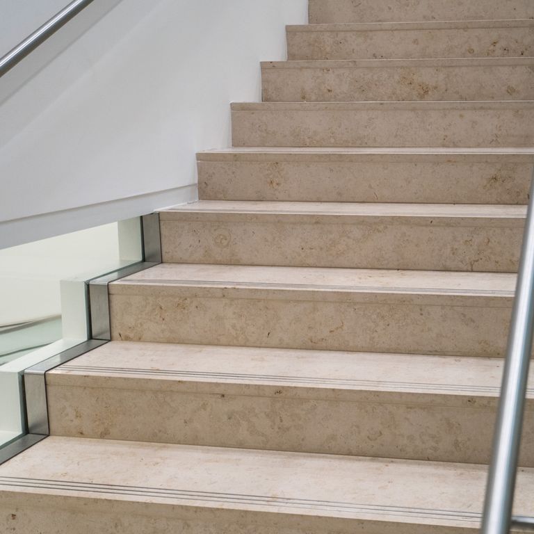 Application image for Bavarian Travertine - Beige. The image shows this material being used for landings and treads. This is a building and landscape stone for outdoor commercial and residential applications. Moderate to higher on the price spectrum.