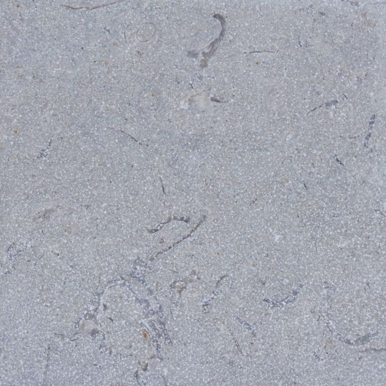 Color/Finish variation image for Blue Harbor Limestone. The surface finishes shown are brushed and sand blasted. Dominant colors shown are blue and gray; with a white secondary. Exhibits 