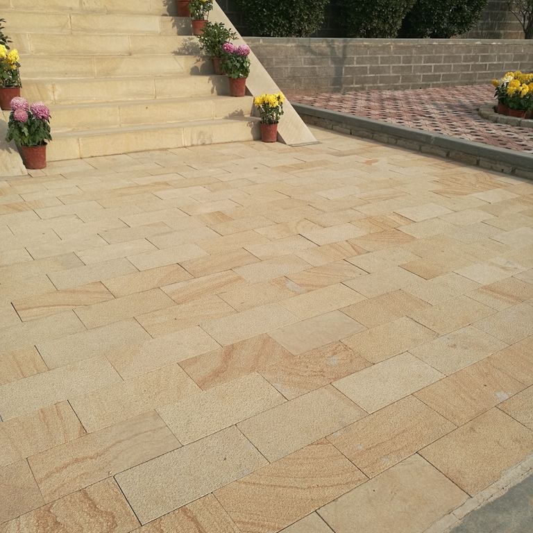 Feature image for Granite - Yangtze Yellow. The image shows this material being used in a patio pavers application. Dominant colors shown are orange/rust and tan. The color mix creates a warm feeling.