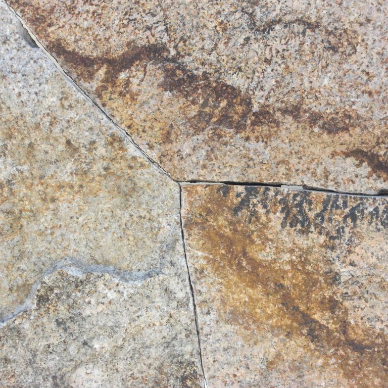Close-up image for Golden Granite Block - Oversized Quarry Skins. The surface finishes shown are split-face and weathered. Dominant colors shown are beige, brown, gray and tan; with orange/rust, purple, white and cream secondaries. Exhibits 