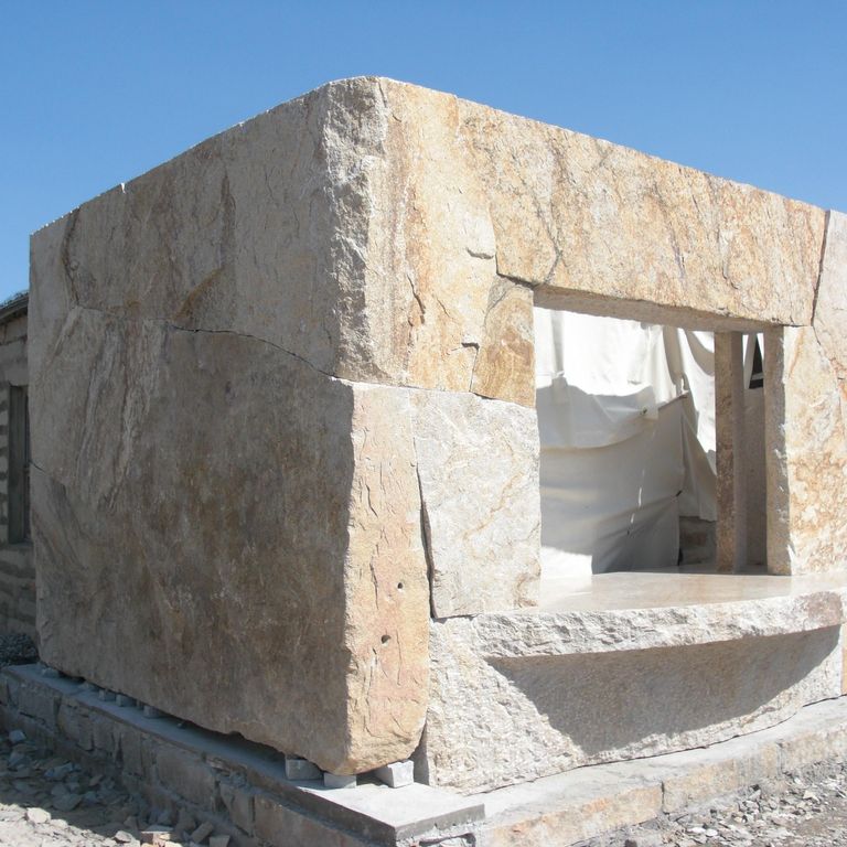 Feature image for Golden Granite Block - Oversized Quarry Skins. The image shows this material being used in a full bed veneer application. Dominant colors shown are beige, gray, tan and cream; with orange/rust and white secondaries. Exhibits 