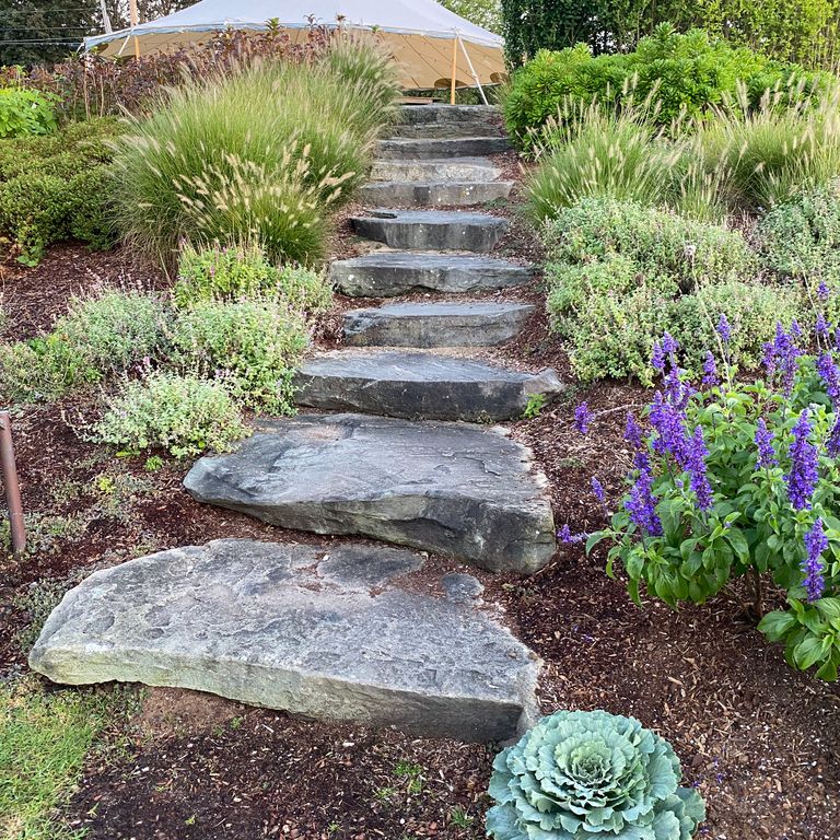 Feature image for Pennsylvania Fieldstone. The image shows this material being used in a monolithic steps application. The dominant color shown is gray; with blue, green, pink, purple, white, tan and cream secondaries. Exhibits 