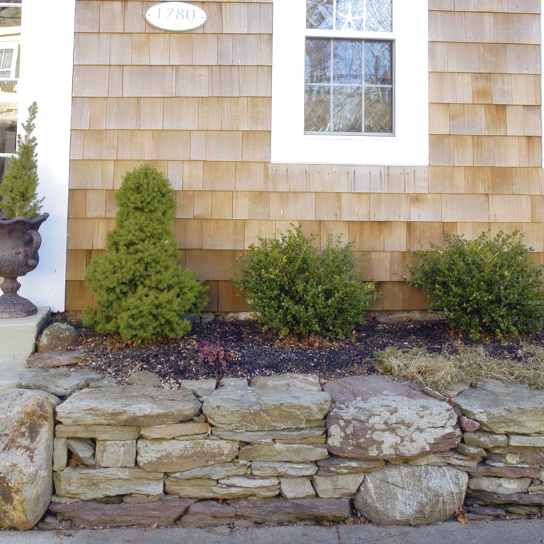 The image shows this material being used in a landscape wallstone application.