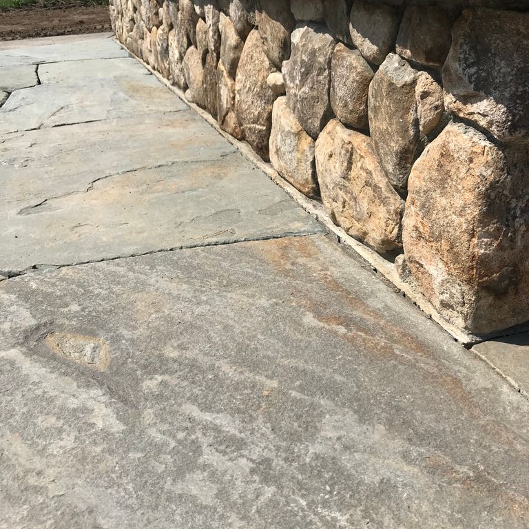 The image shows this material being used in a patio pavers application.