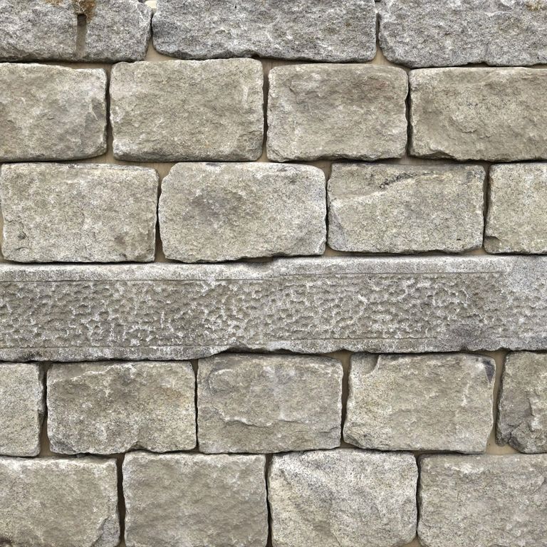 Feature image for Reclaimed Granite Thin Veneer. The image shows this material being used in a thin veneer application. The dominant color shown is gray; with beige, green, white and tan secondaries. The color mix creates a warm feeling. Fine speckled, blotched and cloudy color patterns. Contains some mica.