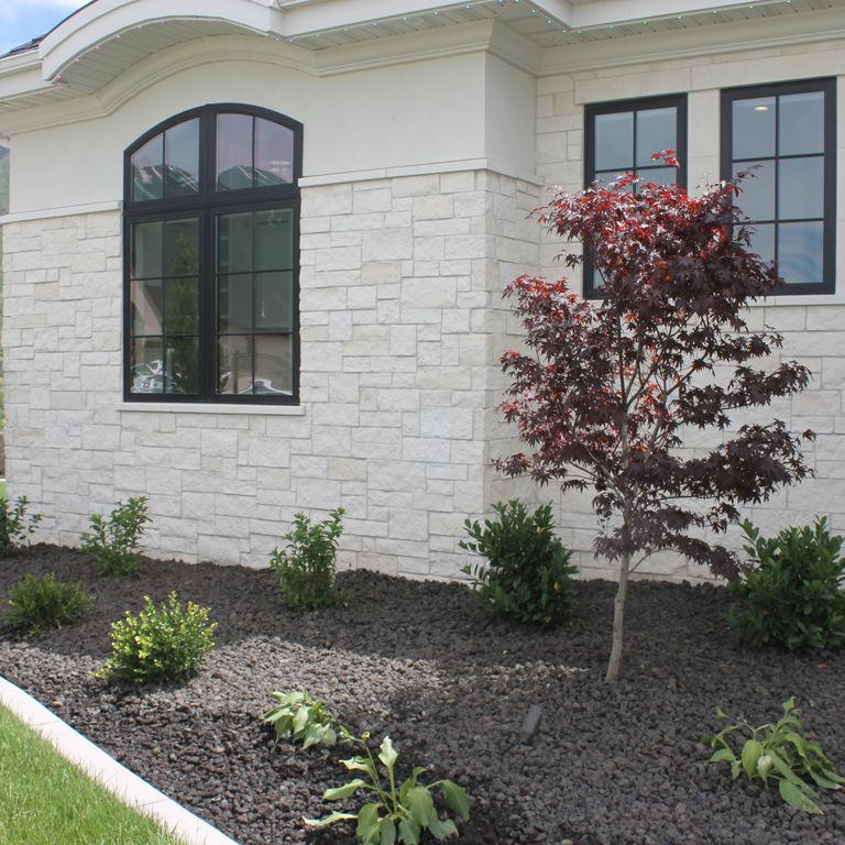 Application image for Blanco Limestone. The image shows this material being used for full bed veneer and thin veneer. The surface finish shown is split-face. The dominant color shown is white; with a cream secondary. The color mix creates a warm feeling.