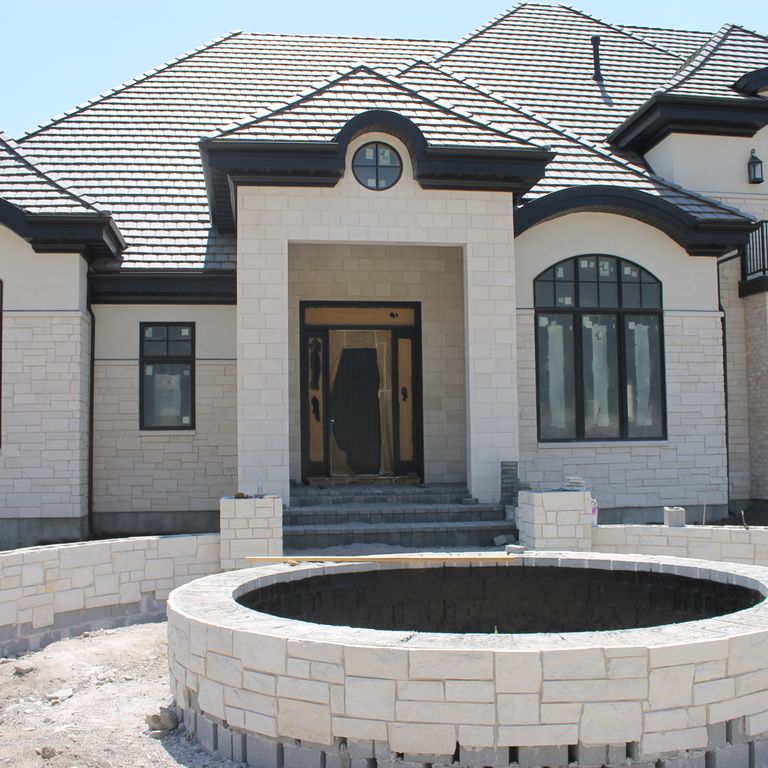 Application image for Limestone - Blanco. The image shows this material being used for landscape wallstone, full bed veneer and thin veneer. The surface finish shown is split-face. The dominant color shown is white; with a cream secondary. The color mix creates a warm feeling. Solid color pattern.