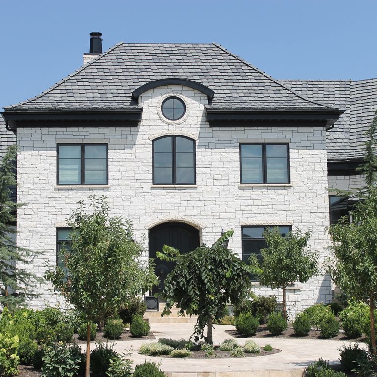 Application image for Blanco Limestone. The image shows this material being used for full bed veneer and thin veneer. The surface finish shown is split-face. The dominant color shown is white; with a cream secondary. The color mix creates a warm feeling. Solid color pattern.