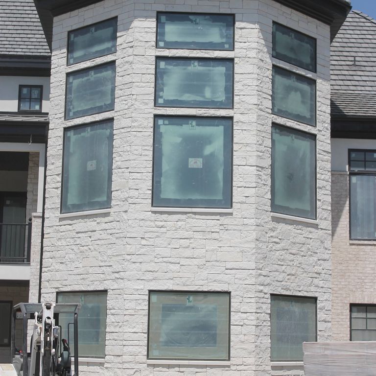 Application image for Blanco Limestone. The image shows this material being used for full bed veneer and thin veneer. The surface finish shown is split-face. The dominant color shown is white; with a cream secondary. The color mix creates a warm feeling. Solid color pattern.