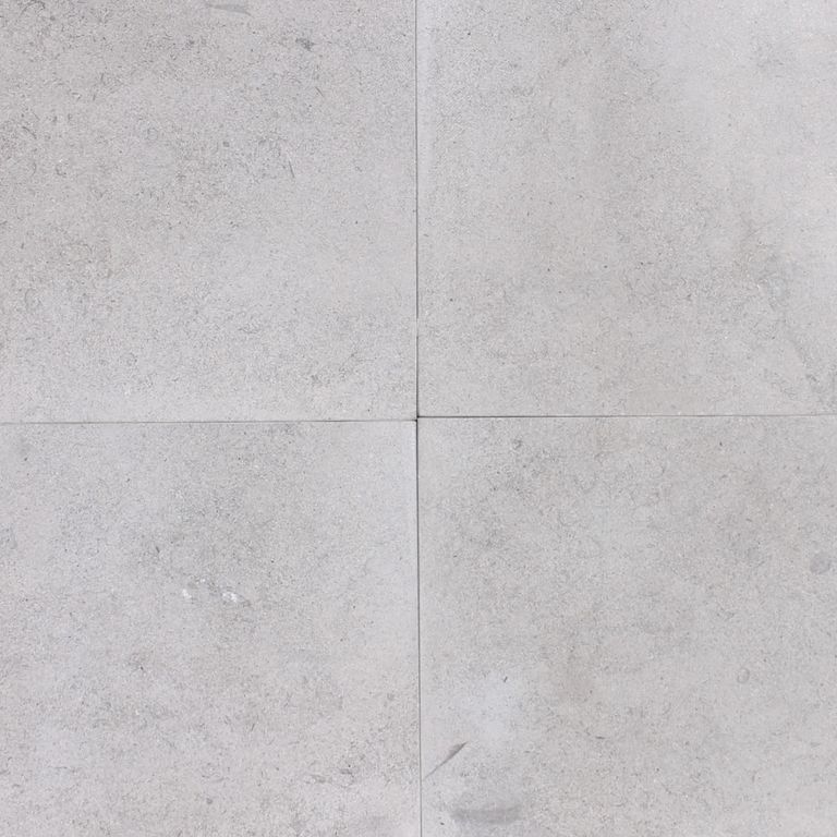 Close-up image for Platinum Limestone. The surface finish shown is honed. The dominant color shown is gray; with pink, purple and white secondaries. The color mix creates a cool feeling. Regular, fine speckled and cloudy color patterns. Contains mineral inclusions.