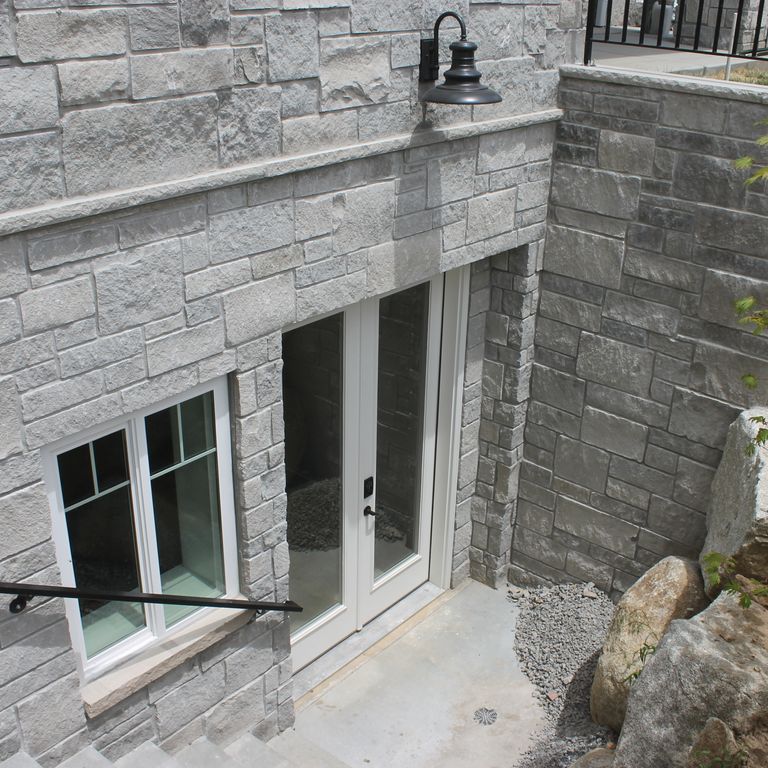 Application image for Platinum Limestone. The image shows this material being used for full bed veneer and thin veneer. The surface finish shown is split-face. The dominant color shown is gray; with a white secondary. The color mix creates a cool feeling. Regular color pattern.