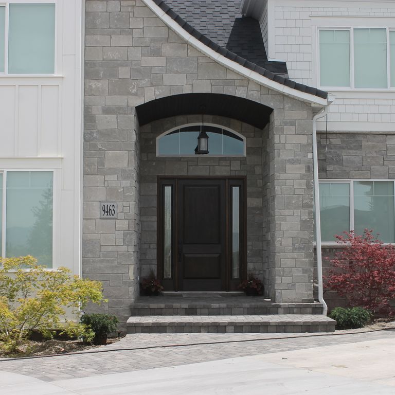 Application image for Platinum Limestone. The image shows this material being used for full bed veneer and thin veneer. The surface finish shown is split-face. The dominant color shown is gray; with a white secondary. The color mix creates a cool feeling. Regular color pattern.