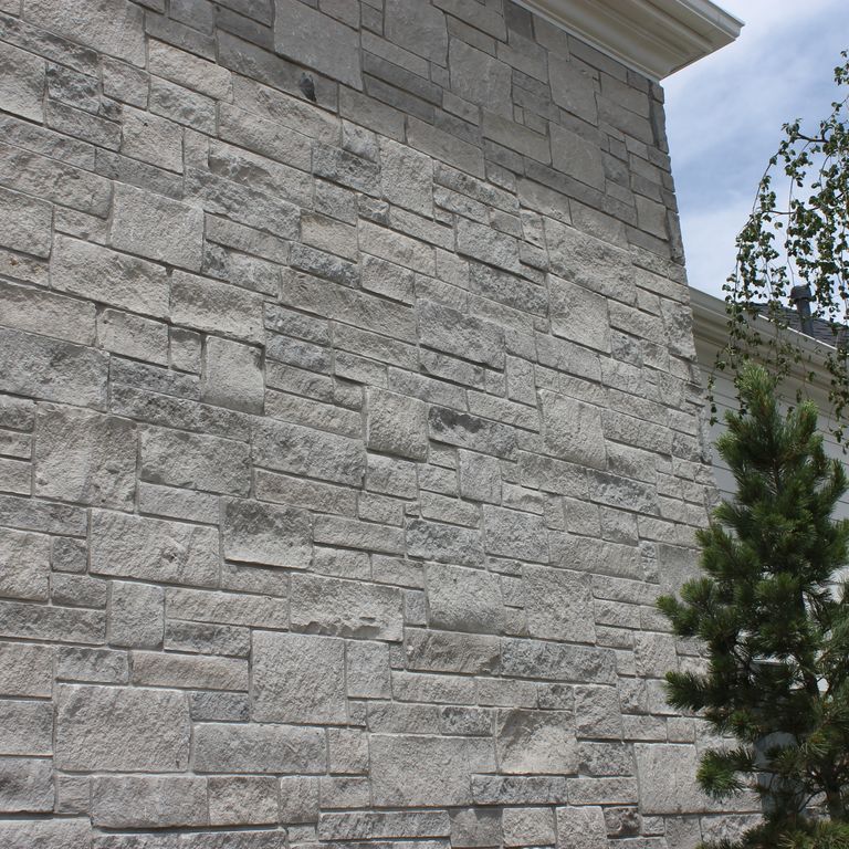Application image for Platinum Limestone. The image shows this material being used for full bed veneer and thin veneer. The surface finish shown is split-face. The dominant color shown is gray; with a white secondary. The color mix creates a cool feeling. Regular color pattern.