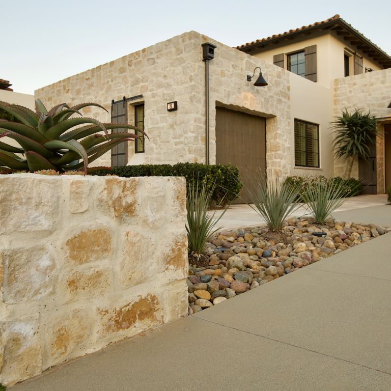 Feature image for Honey Buff Limestone. The image shows this material being used for landscape wallstone, full bed veneer and thin veneer. Dominant colors shown are beige and tan; with brown, gray and cream secondaries. The color mix creates a warm feeling. Regular and blotched color patterns.