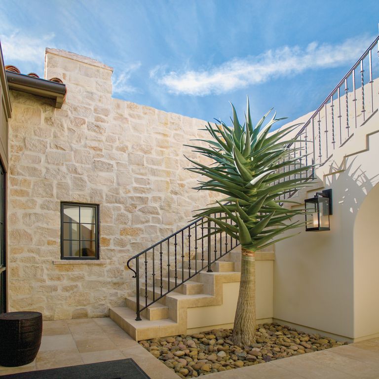 Application image for Honey Buff Limestone. The image shows this material being used for full bed veneer and thin veneer. The surface finish shown is split-face. The dominant color shown is brown; with gray and tan secondaries. The color mix creates a warm feeling. Regular color pattern.