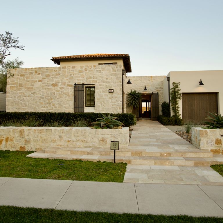 Application image for Honey Buff Limestone. The image shows this material being used for full bed veneer and thin veneer. The surface finish shown is split-face. Dominant colors shown are brown and tan; with gray and orange/rust secondaries. The color mix creates a warm feeling. Regular color pattern.