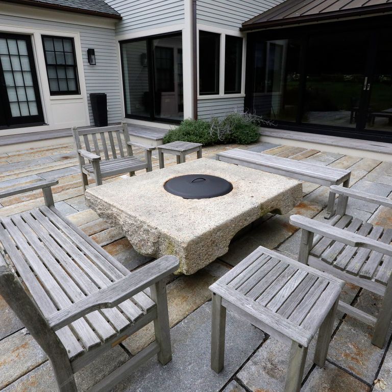 Feature image for Reclaimed Historic Streetscape Stones. The image shows this material being used for outdoor fire concepts and patio pavers. Dominant colors shown are gray and cream; with beige, blue, brown, white and tan secondaries. Random, speckled and blotched color patterns.