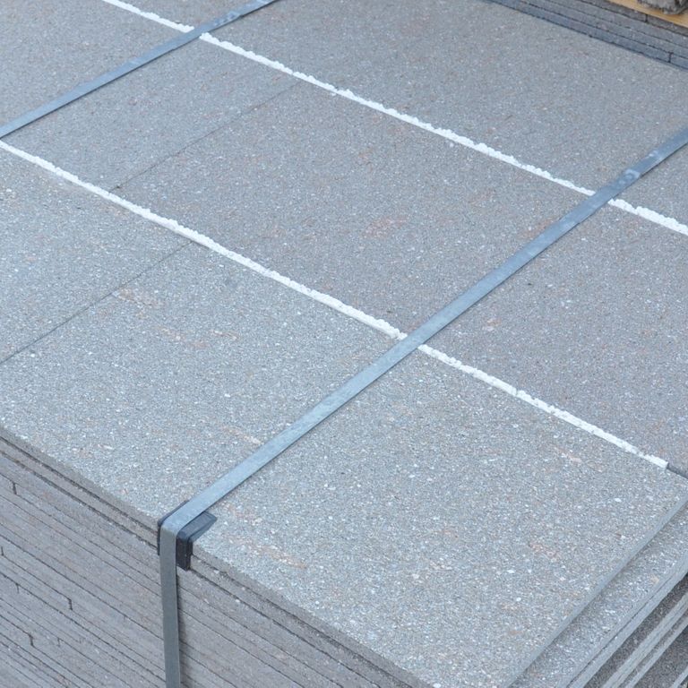 Close-up image for Porphyry Worked Surface - Gray Imperial Roman. The surface finish shown is flamed. The dominant color shown is gray; with a white secondary. The color mix creates a cool feeling. Solid and fine speckled color patterns.