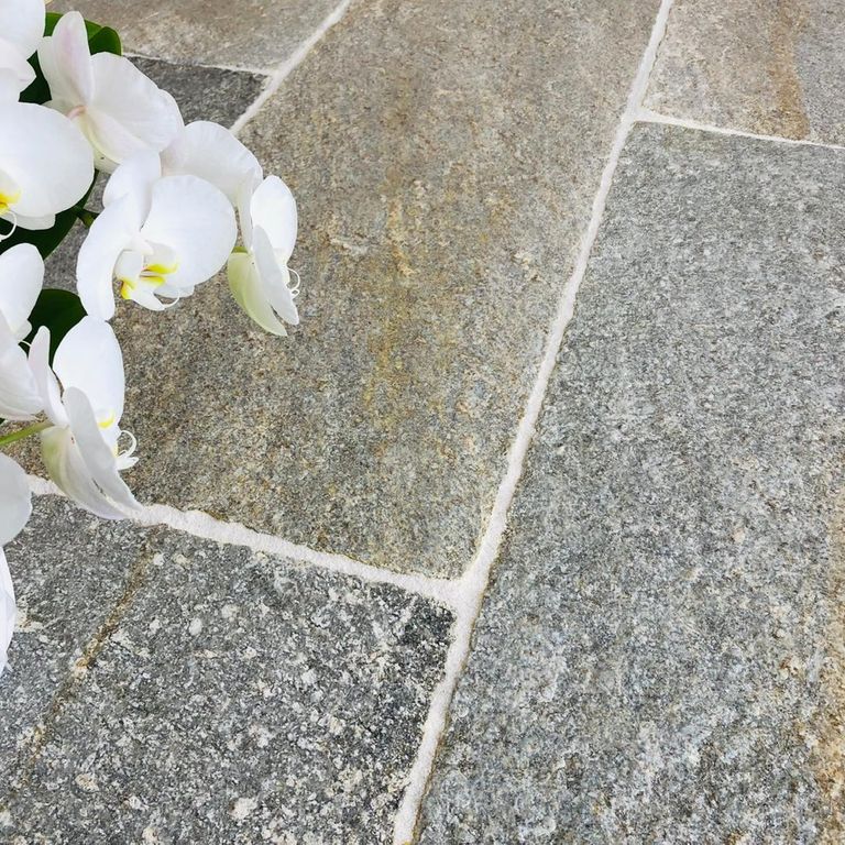 Application image for Pietra Italia Full Color Gneiss. The image shows this material being used in a patio pavers application. The surface finish shown is natural cleft. Dominant colors shown are beige and gray. The color mix creates a warm feeling.