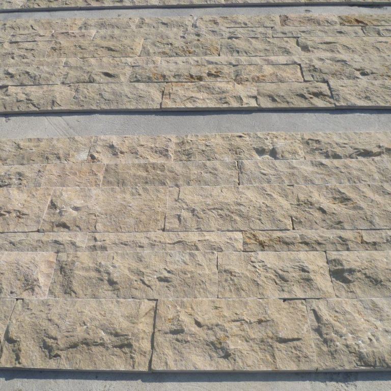 Application image for Cenia Beige Dolomitic Limestone. The image shows this material being used for full bed veneer and thin veneer. The surface finish shown is split-face. The dominant color shown is gray; with a tan secondary. The color mix creates a warm feeling. Solid color pattern.
