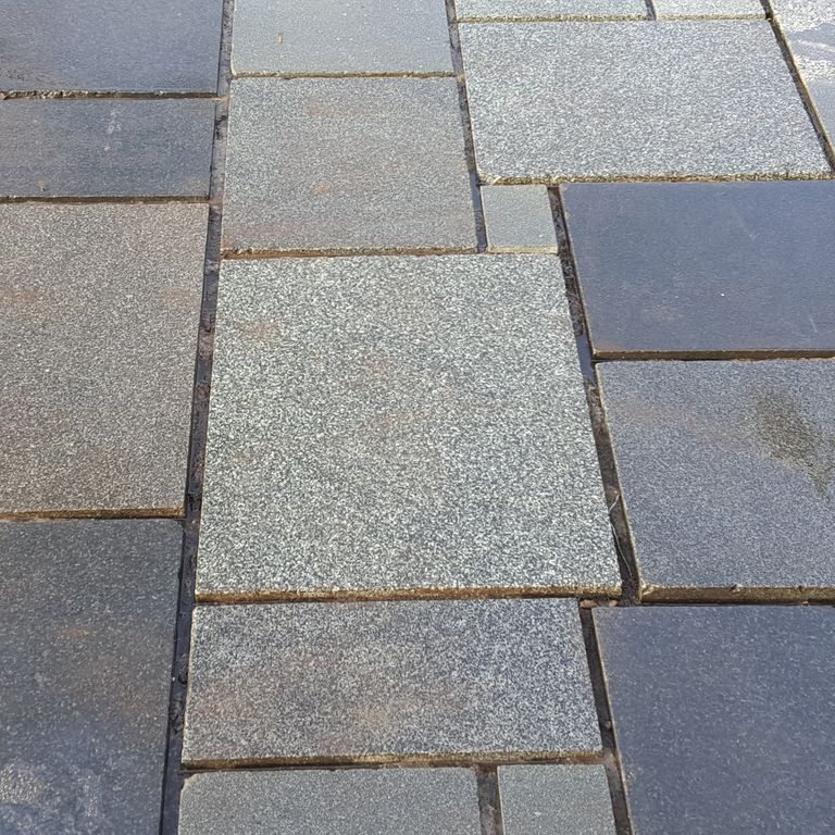 Close-up image for Reclaimed European Granite. The surface finish shown is honed. Dominant colors shown are blue and gray; with beige and purple secondaries. The color mix creates a warm feeling. Speckled color pattern.