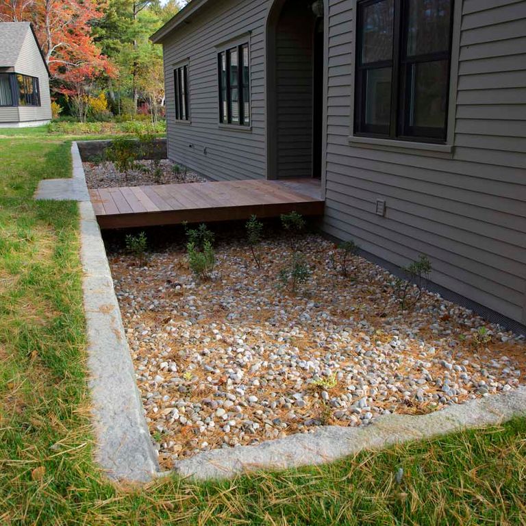 Application image for Reclaimed First Generation Granite Curbstone. The image shows this material being used in a landscape curbing & edging application. This is a building and landscape stone for indoor and outdoor commercial and residential applications. Suitable for general use, freeze-thaw conditions, low heat absorption surfaces, high traffic areas, low slipperiness surfaces and high heel compatibilty situations. Moderate to higher on the price spectrum.