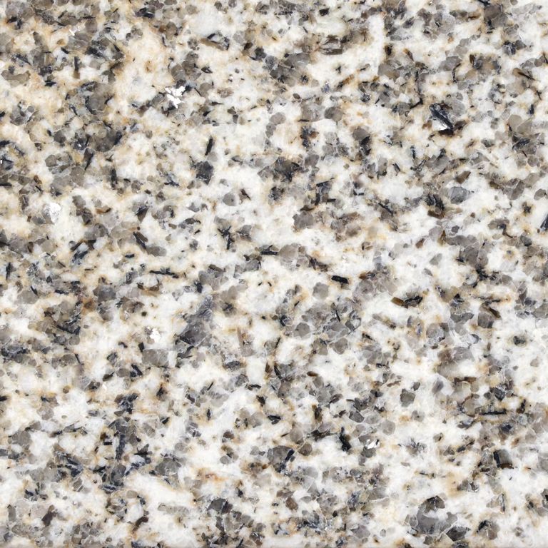 Color/Finish variation image for Yellow Oat Granite. The surface finish shown is polished. Dominant colors shown are gray, white and cream; with beige and brown secondaries. The color mix creates a warm feeling. Coarse speckled color pattern.