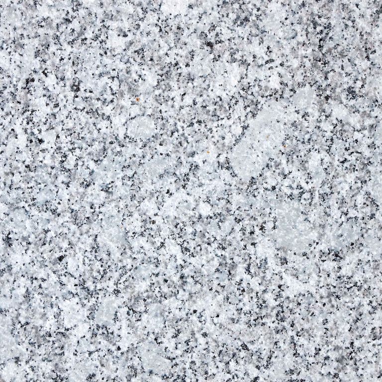 Feature image for Gray Ice Granite. The surface finish shown is flamed. Dominant colors shown are gray and white; with beige, black, pink, purple, white and cream secondaries. The color mix creates a cool feeling. Speckled and blotched color patterns. Contains some mica and mineral inclusions.