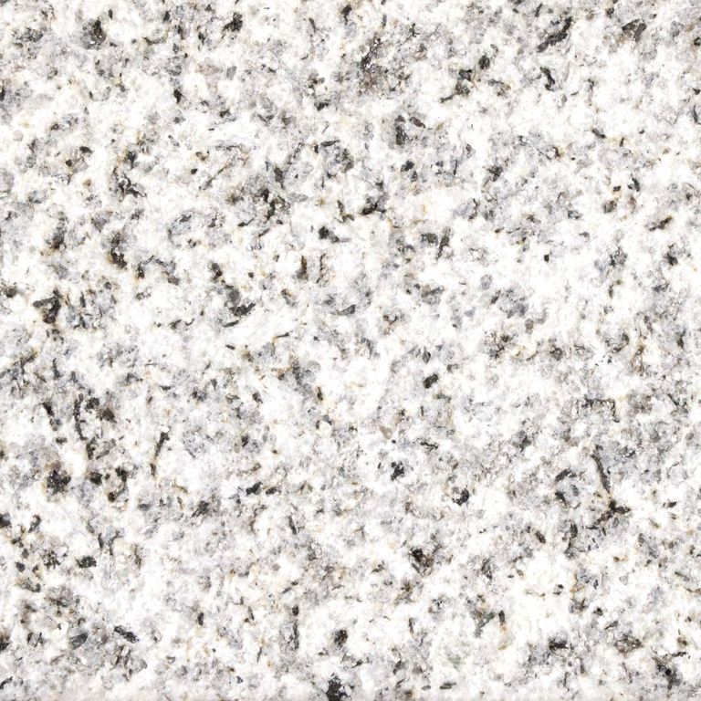 Color/Finish variation image for Crystal White Granite. The surface finish shown is sand blasted. Dominant colors shown are gray, white and cream; with a beige secondary. The color mix creates a warm feeling. Coarse speckled color pattern.
