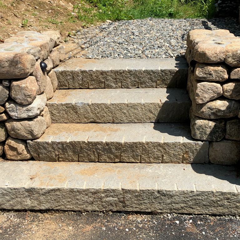 The image shows this material being used in a monolithic steps application. Dominant colors shown are beige and brown; with a gray secondary. Regular color pattern.