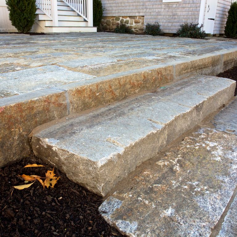 The image shows this material being used in a monolithic steps application. Dominant colors shown are brown and gray; with beige, blue, orange/rust and white secondaries.