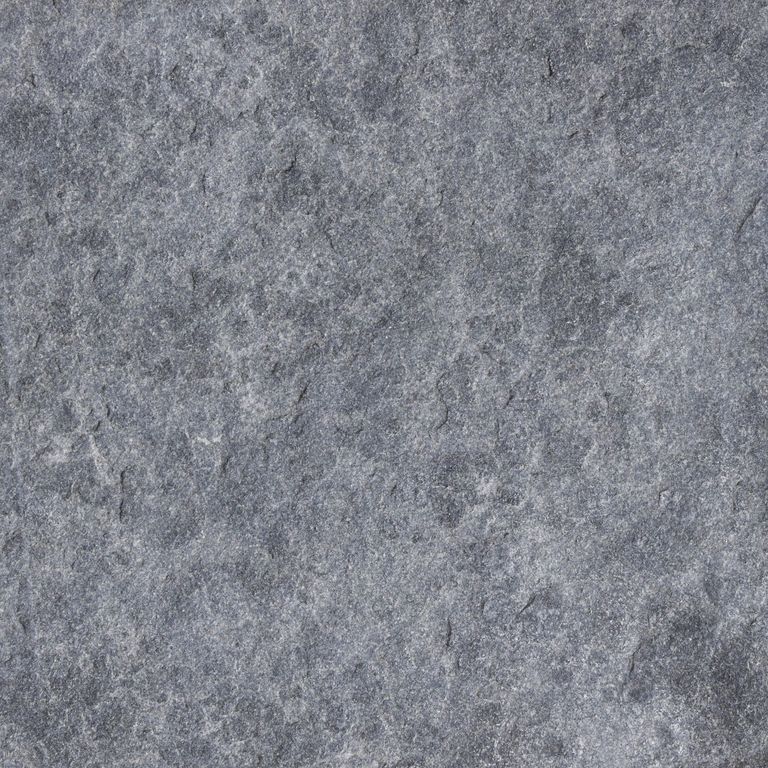 Close-up image for Vietnam Black Basalt. The surface finish shown is flamed. The dominant color shown is gray; with a purple secondary. The color mix creates a cool feeling. Regular color pattern.