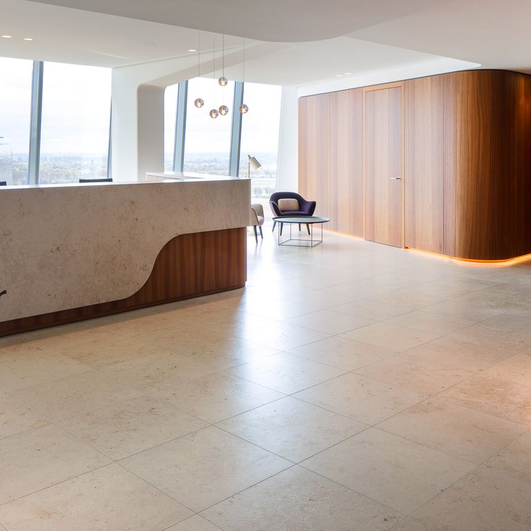 Feature image for Bavarian Limestone Venezia - Beige. The image shows this material being used in an interior floor application. Dominant colors shown are beige, gray and tan; with an orange/rust secondary. The color mix creates a warm feeling. Cloudy color pattern. Contains mineral inclusions.