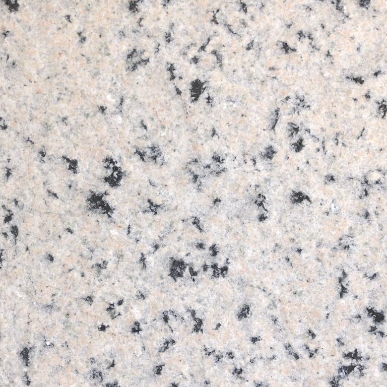Feature image for Granite - Milford Pink. The surface finish shown is flamed. Dominant colors shown are gray, pink and white; with beige, black and cream secondaries. The color mix creates a cool feeling. Coarse speckled color pattern. Contains some mica.