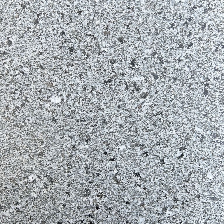 Feature image for Black Star Granite. The surface finish shown is sand blasted. Dominant colors shown are black, blue and gray. The color mix creates a cool feeling. Speckled color pattern. Contains some mica and mineral inclusions.