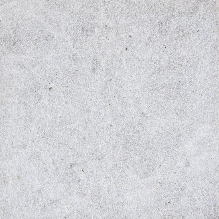 Best close-up image for Dalmatian Limestone. The surface finish shown is sand blasted. Dominant colors shown are beige, gray and white; with blue, pink, purple and cream secondaries. The color mix creates a cool feeling. Cloudy color pattern.