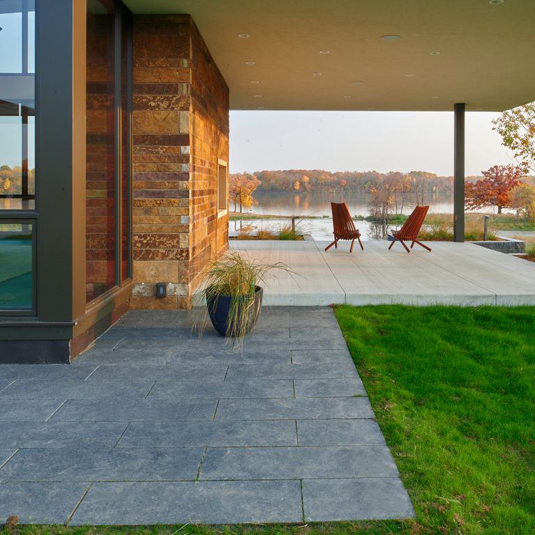 Application image for Midwest Superior Northern Granite. The image shows this material being used in a patio pavers application. The surface finish shown is flamed. Dominant colors shown are blue and gray; with a green secondary. The color mix creates a cool feeling. Regular color pattern.