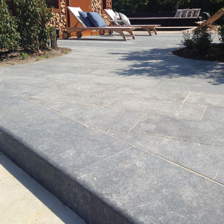 Feature image for Limestone - Kilkenny. The image shows this material being used for landscape curbing & edging and patio pavers. The surface finish shown is flamed. Dominant colors shown are blue and gray; with blue, purple, white and cream secondaries. The color mix creates a cool feeling. Regular color pattern.