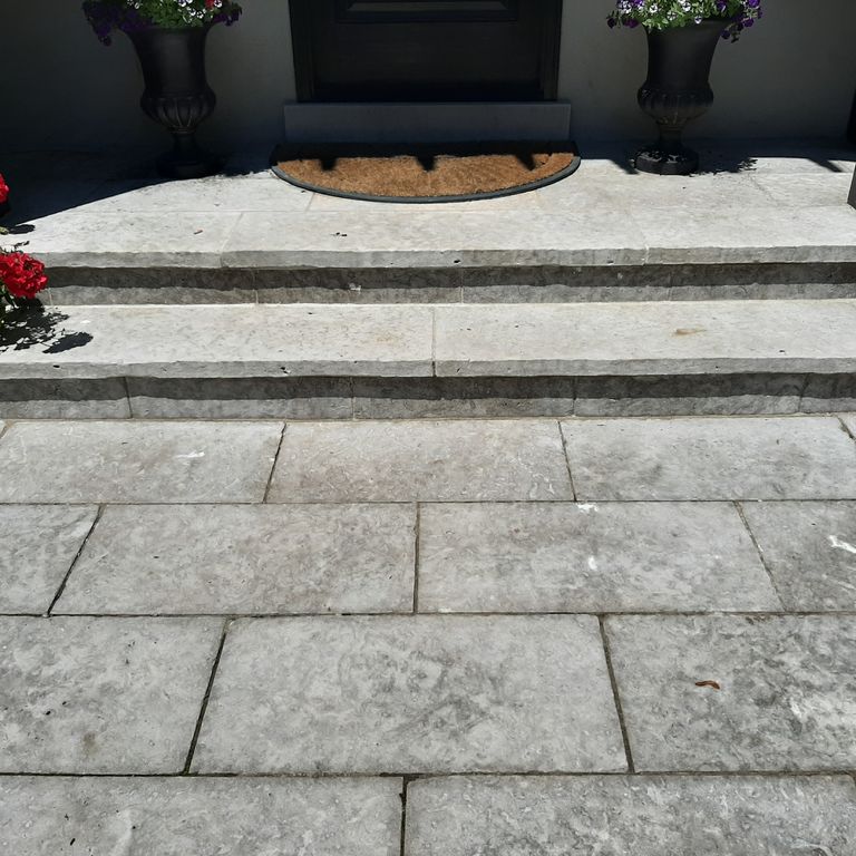 Application image for Madison Limestone. The image shows this material being used for path pavers, patio pavers and treads. The surface finish shown is flamed. The dominant color shown is gray; with beige and white secondaries. Regular color pattern.