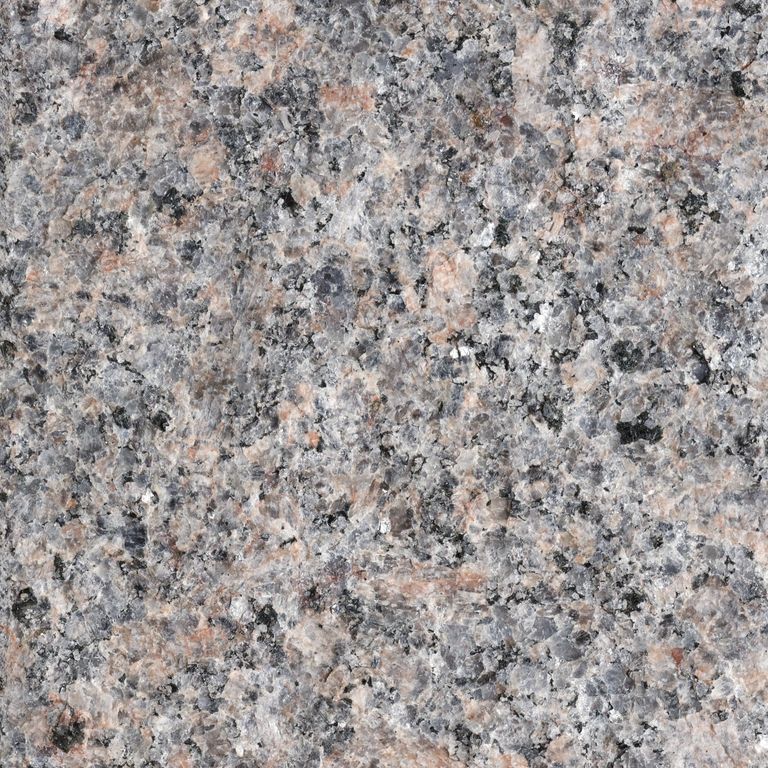 Feature image for Carnelian® Granite. The surface finish shown is flamed. The dominant color shown is gray; with beige, blue, brown, green, orange/rust, pink, purple, white and tan secondaries. The color mix creates a warm feeling. Speckled color pattern. Contains some mica and mineral inclusions.